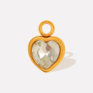 Detailed close-up of a heart-shaped gold-plated pendant with faceted clear crystal stone