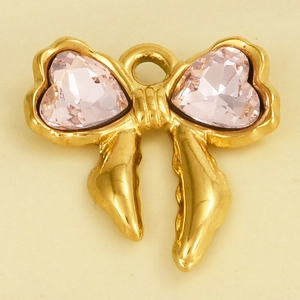Macro shot of gold bow pendant with heart-shaped pink crystals and metal loop