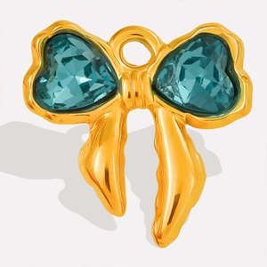 Detailed close-up of bow-shaped pendant with heart-cut blue crystals and gold plating