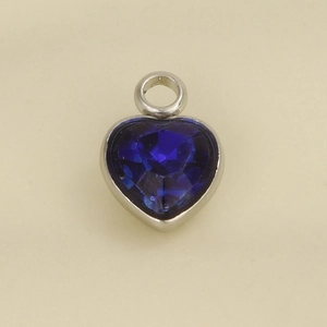 Close-up of heart-shaped stainless steel pendant with a deep blue faceted crystal