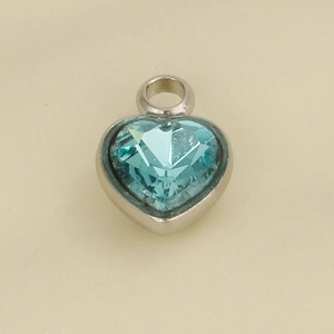 Macro view of light blue heart-shaped crystal pendant with polished silver frame