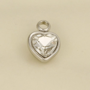 Macro detail of heart-shaped stainless steel pendant with clear crystal and silver finish