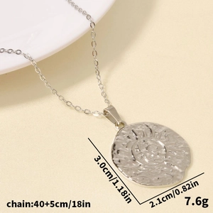 Macro shot of sunburst relief pendant showing size specs on stainless steel coin necklace
