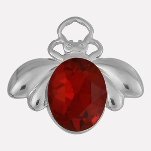 Macro del ciondolo ad ape in argento con cristallo rosso ovale e ali dettagliate