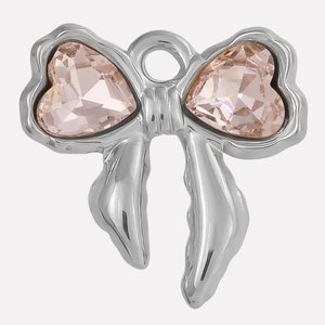 Detail showing a silver bow pendant with two heart-shaped pink crystals for jewelry DIY