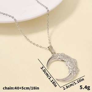 Detailed view of crescent moon and rose engraving on a stainless steel necklace