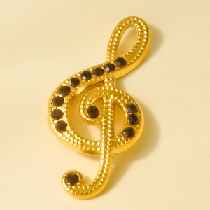 Détail du pendentif clé de sol doré orné de strass sombres pour bijoux musicaux