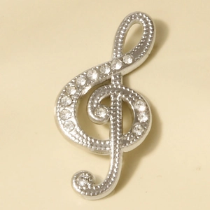 Détail du pendentif clé de sol en argent avec strass et bordure en relief milgrain