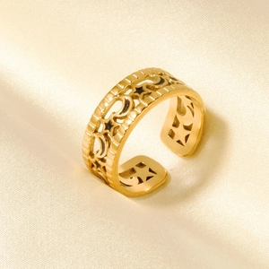 Nahaufnahme eines goldenen Vintage-Rings mit Stern- und Mondgravur auf Seide