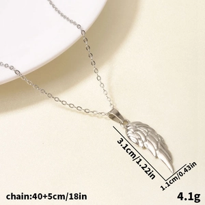 Macro di una collana con ciondolo a piuma in acciaio inossidabile su tessuto