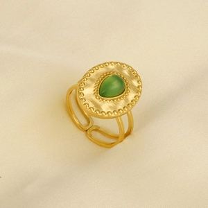 Gros plan d'une bague vintage en acier inoxydable avec pierre verte en forme de poire