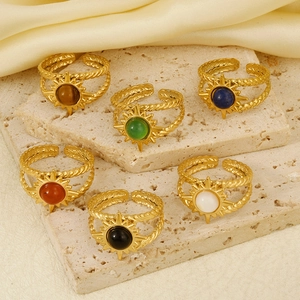 Vintage 304 stainless steel sunburst rings with colorful stones on beige travertine