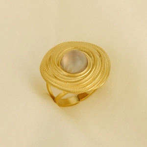 Macro shot of gold vintage ring with concentric circles and a white moonstone