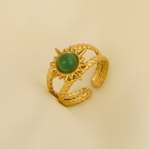 Detailed macro of vintage 304 stainless steel gold ring with sunburst and green stone