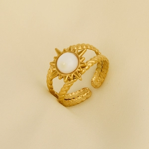 Detail of gold sunburst ring with opal stone on minimalist pleated fabric background