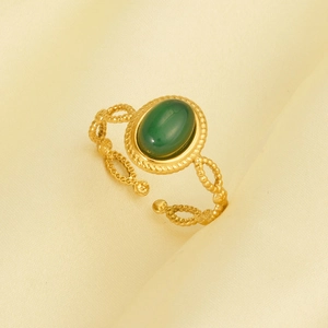 Close-up of vintage oval green stone ring with ornate gold-plated hollow beaded metal details
