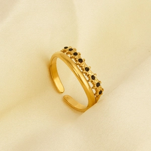 Detail of 18k gold plated double-layer ring with black zircon stones on satin
