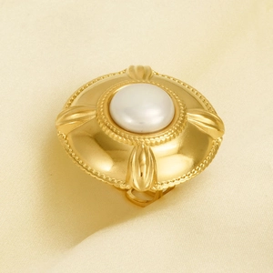 Detail of vintage 304 stainless steel ring with large white pearl and gold relief texture