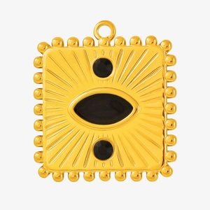 Detailed macro view of a vintage gold pendant with black enamel inlays and beaded edges