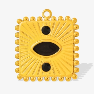 Macro view of vintage gold plated square pendant with black evil eye and sunburst texture