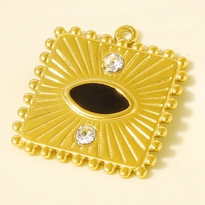 Macro detail of gold evil eye pendant with black enamel and radiant sunburst texture