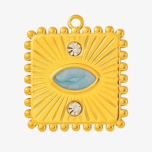 Close-up of golden vintage pendant with blue stone, sunburst pattern and rhinestones