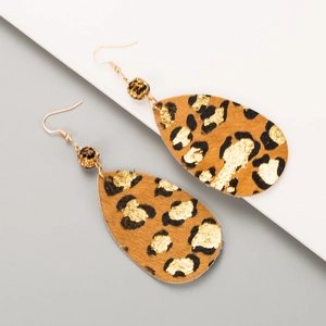 Macro detail of teardrop leopard print earrings with gold foil texture and golden hooks