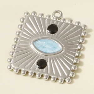 Macro detail of a silver stainless steel square pendant featuring a blue evil eye design