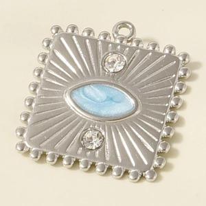 Detail of square silver pendant featuring blue eye enamel, radial textures and zircon stones