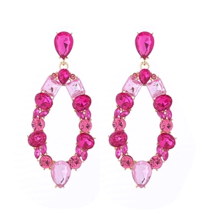 Detail of large oval hoop earrings featuring pink resin stones in a golden alloy setting