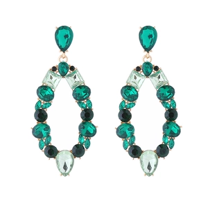 Detail of vintage gold drop earrings with emerald and grass green crystals set in metal