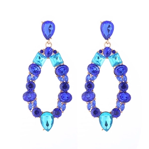 Detailed view of large gold alloy earrings set with colorful blue teardrop crystals