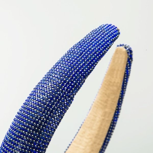 Baroque padded headband featuring densely set royal blue rhinestones on a thick frame