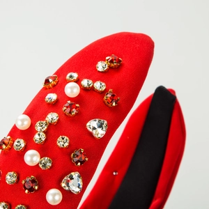 Red knit headband with studded pearls and heart-shaped crystals for high-volume hair look