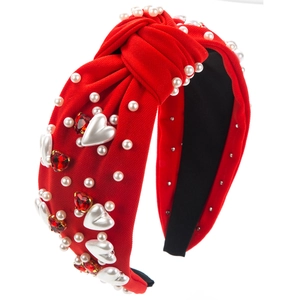 Détail du serre-tête noué rouge avec perles et cristaux en forme de cœur pour un style chic