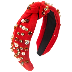 Detail of red knitted headband featuring hand-sewn pearls and bright red crystals