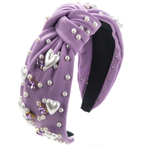 Détail du serre-tête baroque avec cristaux de cœur violets et perles sur tissu noué