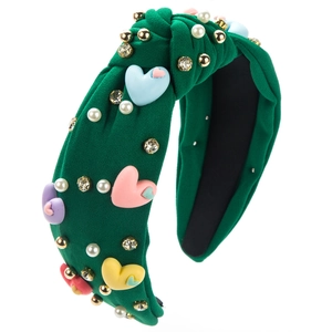 Détail du serre-tête tricoté vert avec cœurs 3D colorés, perles et strass brillants