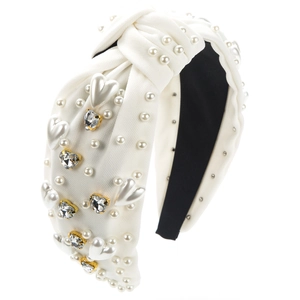 Gros plan d'un serre-tête noué blanc avec perles et strass en forme de cœur brillant