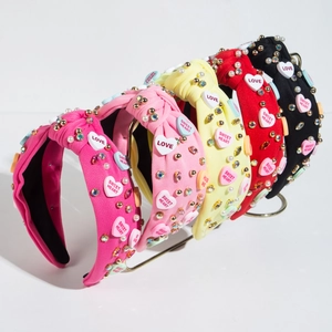 Detail of knots on headbands with rhinestones, pearls and heart-shaped love patches
