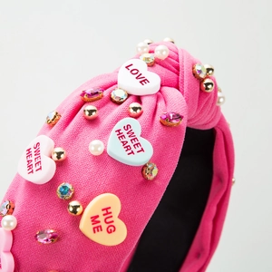 Pink knotted headband with heart sequins, rhinestones and pearls for a sweet aesthetic