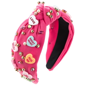 Detail of pink knotted headband with rhinestones, pearls and heart charms