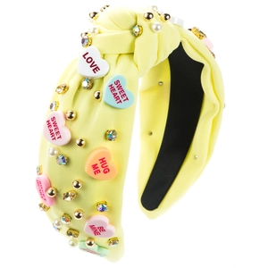 Detail of yellow knotted headband with colorful love heart beads and white pearls