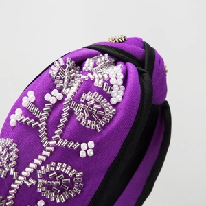 Purple knot headband with handmade pearl flower embroidery and gold rhinestone sun motifs