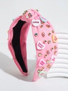 Detail view of pink knotted headband featuring colorful heart charms and beads