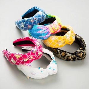 Detail of assorted knotted sequin headbands in various colors with high-end handmade embroidery
