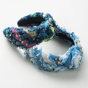 Close-up of denim knotted headbands featuring frayed edges and colorful rhinestones