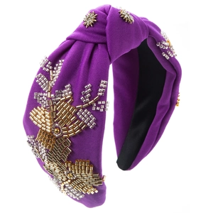 Macro view of purple fabric headband with handmade beadwork and crystal floral patterns