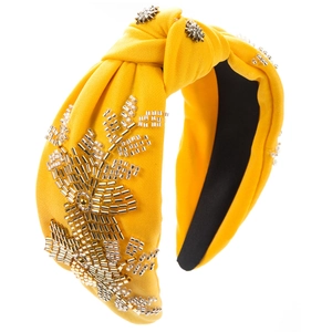 Detail of yellow fabric headband with hand-stitched gold beads and crystal star embroidery