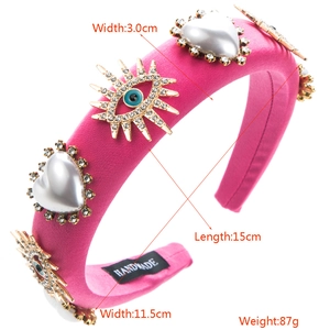 Detailed size view of rose red padded headband with pearls, evil eye, and handmade tag
